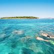 two people swimming in the ocean with an island in the background