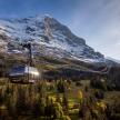 a ski lift in front of a snow covered mountain