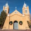 a church with two towers with christmas wreaths on it