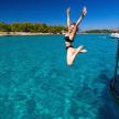 a woman jumping off of a boat in the water