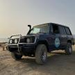 a blue jeep parked on a sandy beach