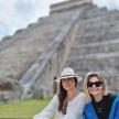 two women sitting in front of the pyramid