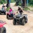 a group of people riding atvs on a dirt road