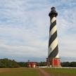 a black and white lighthouse sitting in a field