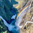 an aerial view of a waterfall with a rainbow