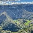 an aerial view of a valley with trees and mountains