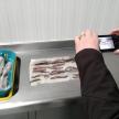 a person taking a picture of a shelf of meat