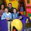 a family sitting in a car in a toy car ride