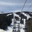 a group of people riding a ski lift in the snow