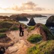 a couple standing on a beach near the ocean