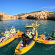 a group of people and a dog in kayaks on the water