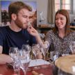 a man and a woman sitting at a table with wine glasses