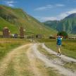 a person walking down a dirt road in a field