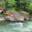 a person is jumping off a rock in a river