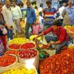 a group of people standing around a market with flowers