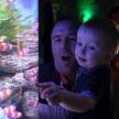 a man holding a little boy in front of a aquarium