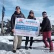 a group of people holding a large sign in the snow