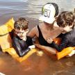 a woman and two boys in a raft in the water