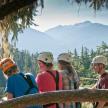a group of people wearing helmets looking at the mountains