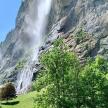 a waterfall on the side of a mountain with trees