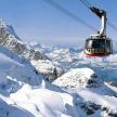 a ski lift flying over a snow covered mountain