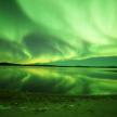 an aurora over a body of water with a river