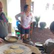 a group of people standing around a table preparing food