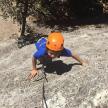 a young boy in an orange helmet playing in the sand