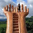 a woman standing on top of a giant hand