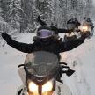 a group of people riding on a snow covered motorcycle