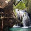 a waterfall in a cave with a pool of water