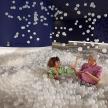 two people sitting in a pool of balls
