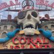 a skull on the top of a carnival center sign