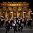 a group of musicians posing in front of a building