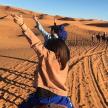 a woman in the desert with her arms in the air