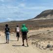 a group of people walking down a dirt road