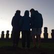 three people standing in front of an ancient monument