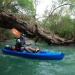 a man in a blue kayak on a river