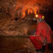 a man is sitting in a cave with ice formations