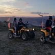 a group of people sitting on atvs on a mountain