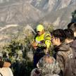 a crowd of people watching a man standing on a mountain