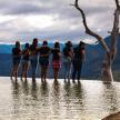 a group of people standing on the edge of a body of water
