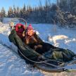 a woman riding in a sled pulled by a person
