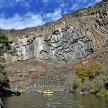 a river with two yellow kayaks in front of a mountain