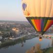 a hot air balloon flying over a river