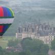 a colorful hot air balloon flying over a castle