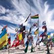a bunch of flags in the sand on a beach
