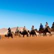 a group of people riding horses in the desert