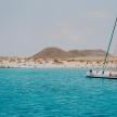 a boat in the water with a beach in the background
