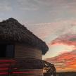 a hut with a straw roof and a chair with a sunset
